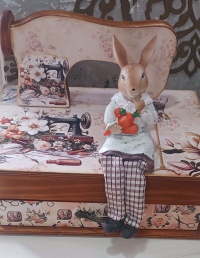 Manualidad en madera con forma de máquina de coser acompañado de un conejo sentado