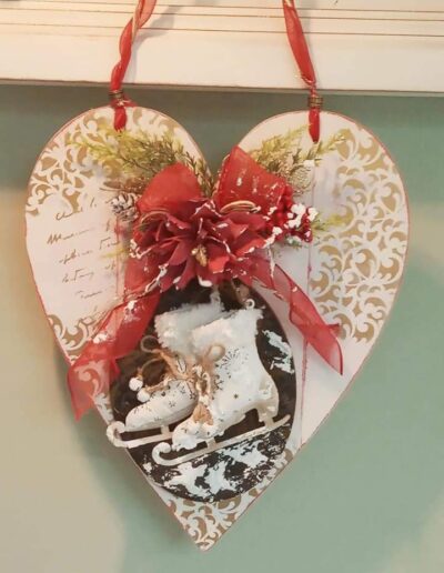Manualidad navideña en madera con forma de corazón decorada con detalles festivos